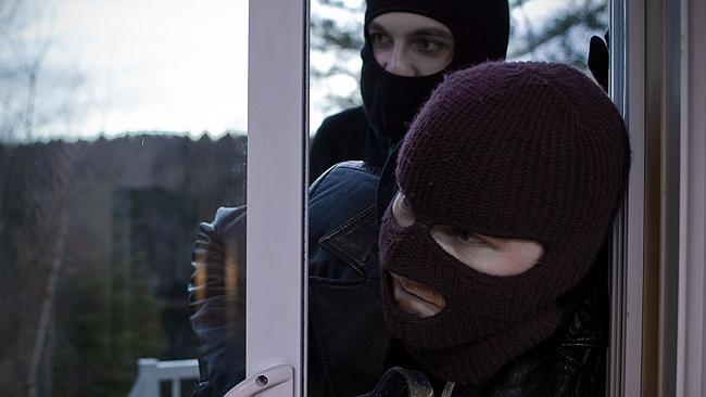 Generic picture of two masked burglars entering house through glass sliding door.