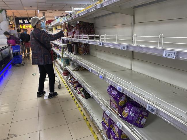 BEIJING, CHINA - APRIL 25: (Editors note: image taken with mobile phone camera) A woman shops as some shelves are nearly empty shelves in the instant noodle aisle after they were picked over at a supermarket in Chaoyang District on April 25, 2022 in Beijing, China. China is trying to contain a spike in coronavirus cases in the capital Beijing after dozens of people tested positive for the virus in recent days, causing local authorities to initiate mass testing in some areas and to lockdown some neighbourhoods where cases are found in an effort to maintain the country's zero COVID strategy. (Photo by Kevin Frayer/Getty Images)