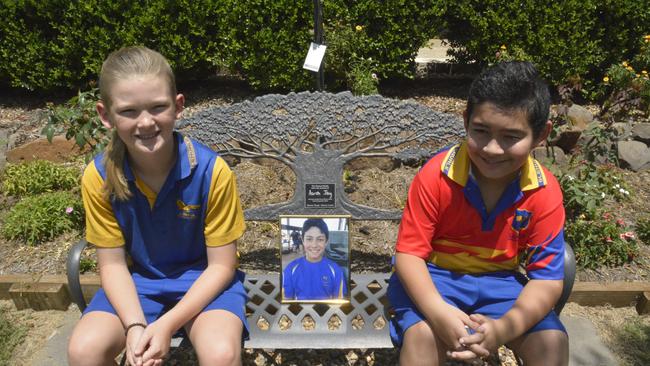 Danny Booth and Aiden Preston always visit Aaron’s bench at Glenvale State School, and remember good times. Danny hopes to raise $5000 and donate his hair to assist cancer affected families in memory of Aaron. Picture: Morgan Burley