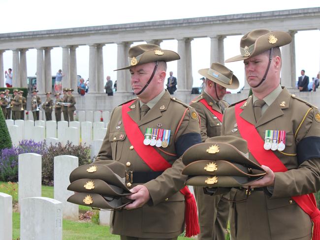 Two Australian soldiers carry slouch hats at the funeral service of three unknown World War I diggers at the war cemetery near Pozieres in northern France. Picture: AAP