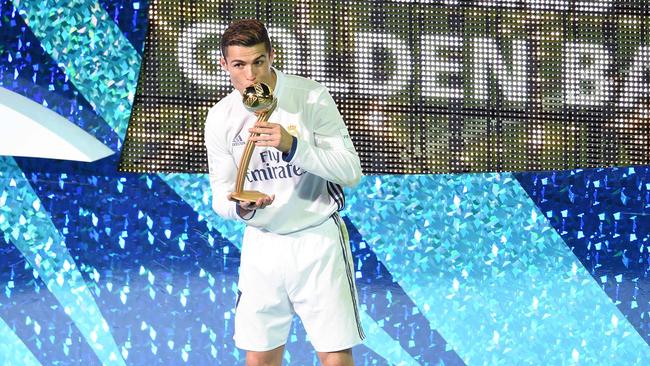 Real Madrid's forward Cristiano Ronaldo kisses the Golden Ball trophy.