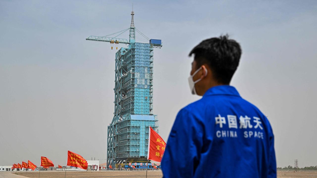 A staff member from the China space program stands before the launch platform of the Shenzhou-16 Manned Space Flight Mission one day before launch. Picture: AFP