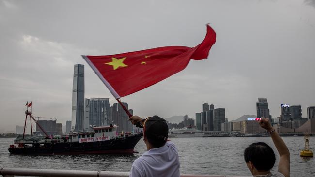 Pro-Beijing demonstrators wave the Chinese national flag during a rally in front of the Legislative Council Complex in Hong Kong. Picture: Getty Images