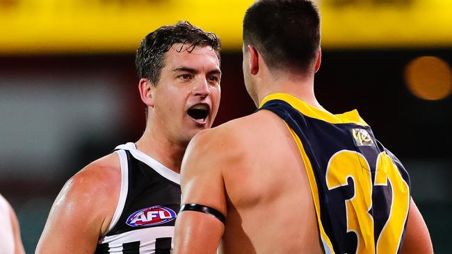 Tom Rockliff of the Power and Darcy Fogarty of the Crows face off.