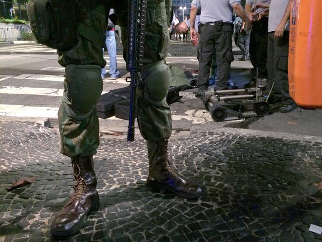 Brazil's armed forces stand on duty as bomb disposal equipment is packed away following a controlled explosion in the Copacabana district of Rio.