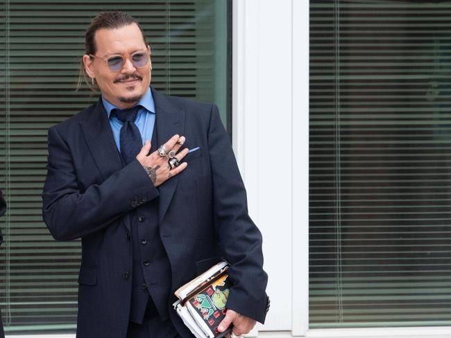 Johnny Depp gestures to fans during a recess outside court but did not attend to hear the verdict. Picture: Cliff Owen/Consolidated News Pictures/Getty Images.