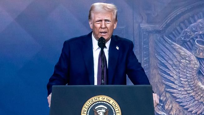 US President Donald Trump is seen on a giant screen during his address by video conference at the World Economic Forum (WEF) annual meeting in Davos on January 23, 2025. (Photo by Fabrice COFFRINI / AFP)