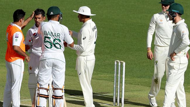 Medics attend to Pakistan’s Asad Shafiq after he was struck by the ball on his helmet against Australia A. Picture: AAP