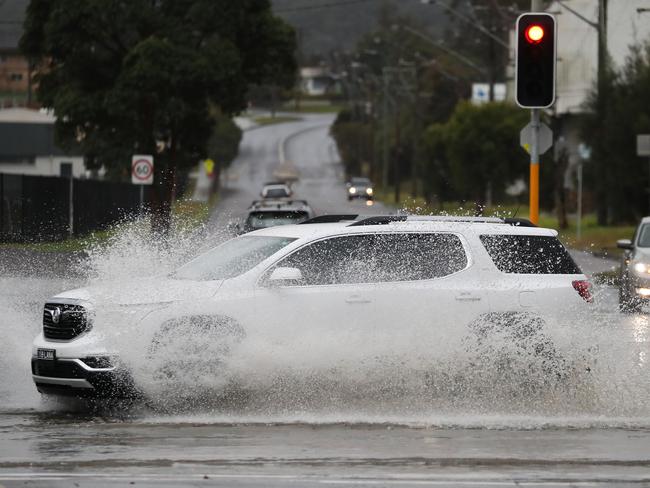 Heavy rains have caused flooding across the Central Coast Highway at West Gosford. Picture: David Swift