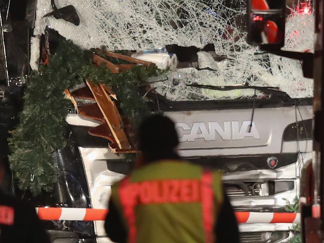 BERLIN, GERMANY - DECEMBER 19: Police stand near a black lorry that ploughed through a Christmas market on December 19, 2016 in Berlin, Germany. At least nine people have died as police investigate the attack and whether it is linked to a terrorist plot. (Photo by Sean Gallup/Getty Images)