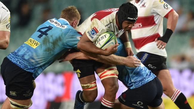 The Lions’ Marvin Orie is tackled by Waratahs players Tom Staniforth (left) and Michael Hooper on Friday night.