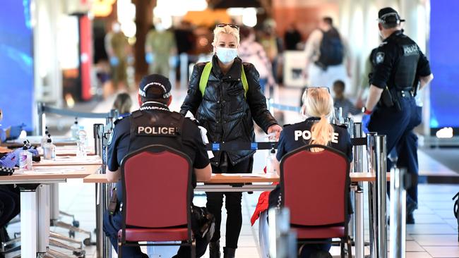 An incoming passenger is screened by police as she arrives at Brisbane domestic airport. Picture: NCA NewsWire/Dan Peled