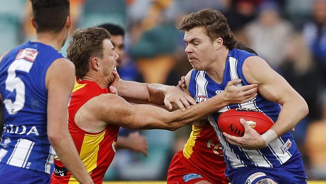 Cameron Zurhaar of the Kangaroos fends off Nick Holman of the Suns during the 2021 AFL Round 15 match between the North Melbourne Kangaroos and the Gold Coast Suns at Blundstone Arena on June 26, 2021 in Hobart, Australia. (Photo by Dylan Burns/AFL Photos via Getty Images)