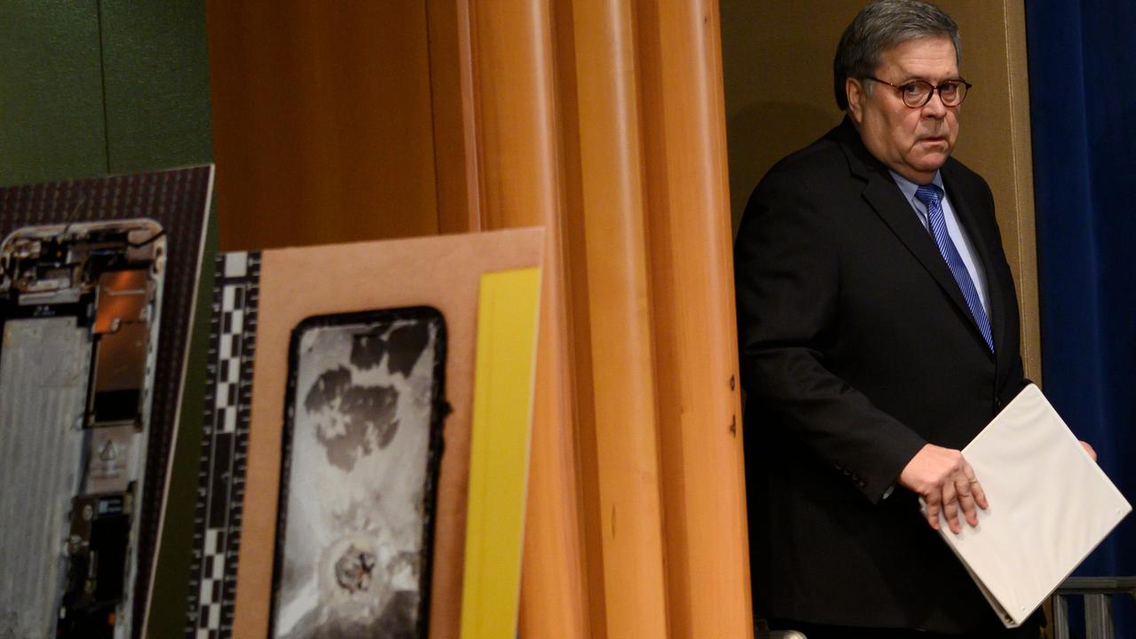 US Attorney-General William Barr walks past pictures of the shooter's mobile phone as he arrives at a press conference. Picture: Andrew Caballero-Reynolds / AFP