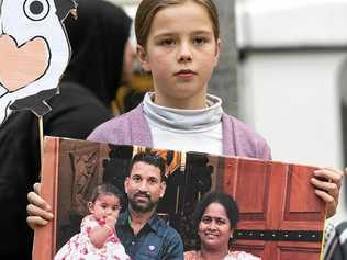 BRING THEM HOME: A girl holds a family portrait during a rally to stop the deportation of a Biloela Sri Lankan family at the State Library of Victoria on Sunday. Picture: ELLEN SMITH