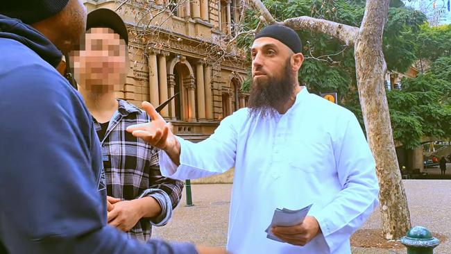 Mr Ousayd and volunteers speaking with a member of the public at Sydney's Town Hall. Picture: YouTube