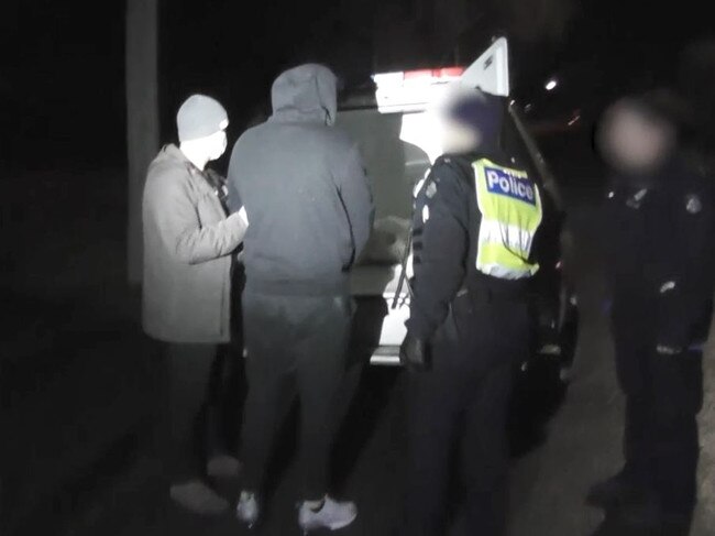 A man is spoken to by police during raids linked to the Mongols.