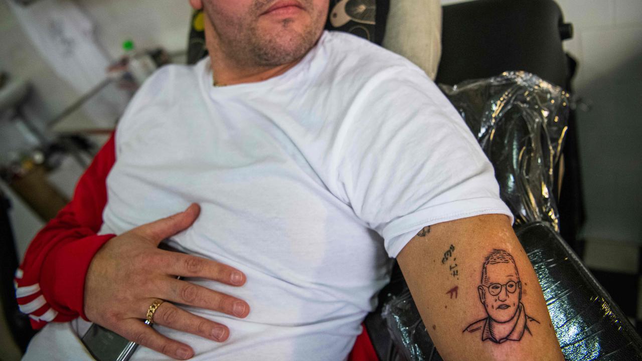 Gustav Lloyd Agerblad looks at his new tattoo of Sweden's state epidemiologist Anders Tegnell, the face of the country's response to the coronavirus pandemic. Picture: AFP