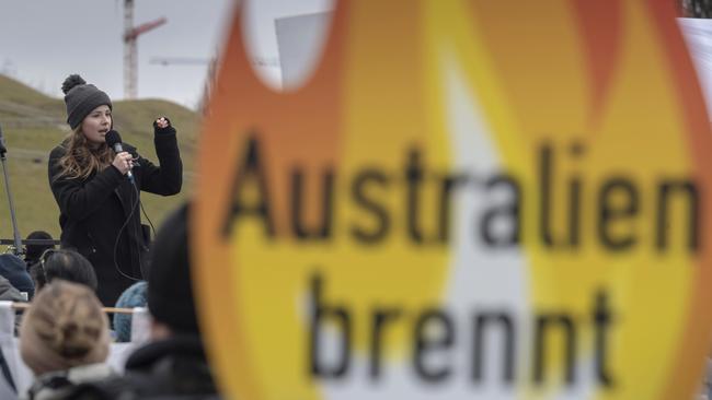 Climate activist Luisa Neubauer speaks outside the Siemens AGM in Munich behind a poster declaring “Australia burns”. Picture: AP