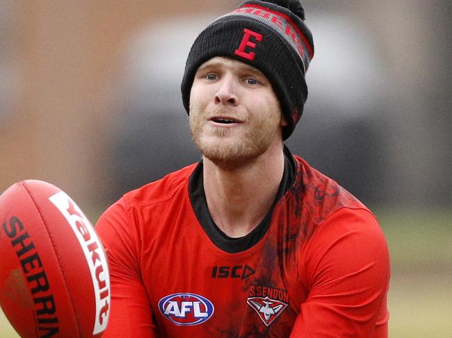 Essendon Bombers player Michael Hurley (right) handballs during a team training session at the Hangar in Melbourne, Friday, May 11, 2018. (AAP Image/Daniel Pockett) NO ARCHIVING