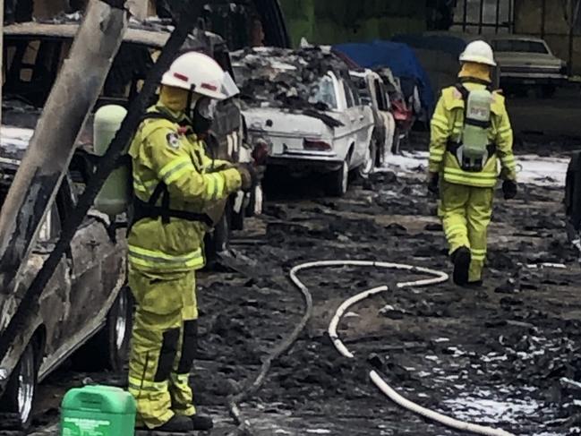 Firefighters in the remains of a storage shed containing a number of rare and collectable vehicles. Picture: Jim O'Rourke