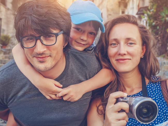 Family of three with a map and a camera, traveling in Europe  in summer