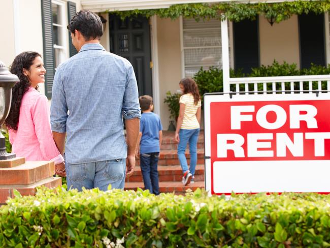 Hispanic family outside home for rent holding hands looking at each other happy