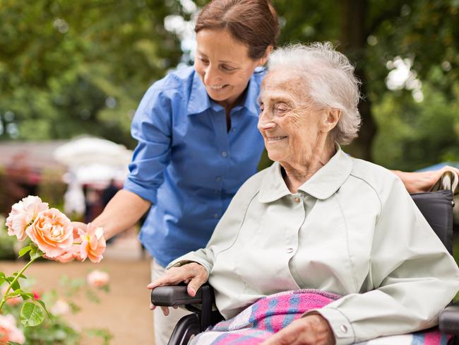 CAREERS: Aged care is a growing employment industry. Picture: iStockSenior woman sitting on a wheelchair with caregiver, walking in a park