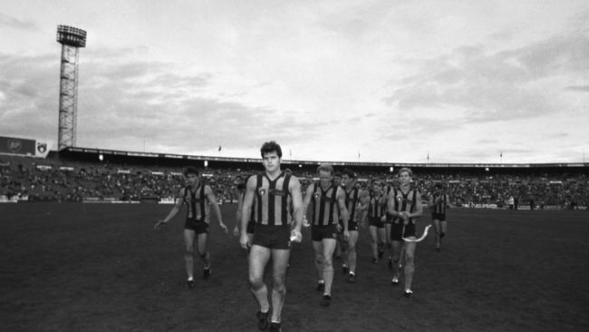 Jason Dunstall leads his teammates from Waverley after booting 17 goals.