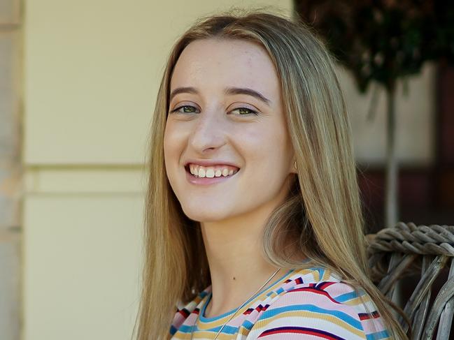 Student and author Georgie Trotter with her book about money, and with her dog Kobbie Mae, pictured at home, Tuesday December 4, 2018 - pic AAP/MIKE BURTON