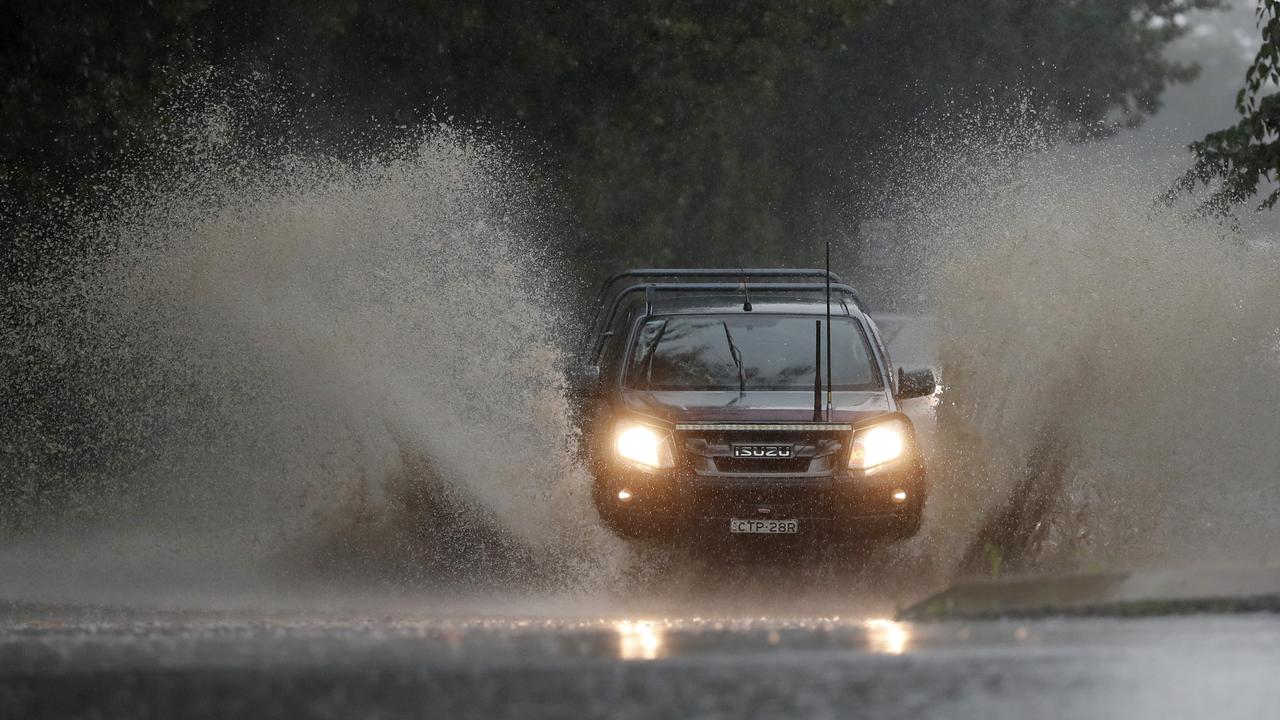 Motorists driving through a flooded Old Kurrajong Rd near North Richmond. Picture: Jonathan Ng