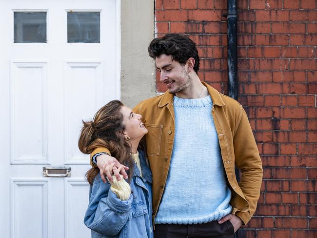 A medium close up view of a young couple stood outside of their new home in Whitley Bay. They are stood affectionately and smiling at each other.first-home buyer stock photo from istock for herald sun realestate