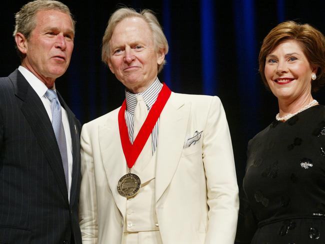 Then US President George W Bush, left, poses with author Tom Wolfe, centre, and first lady Laura Bush in 2002 as the author received the National Humanities Medal. Picture:  AP