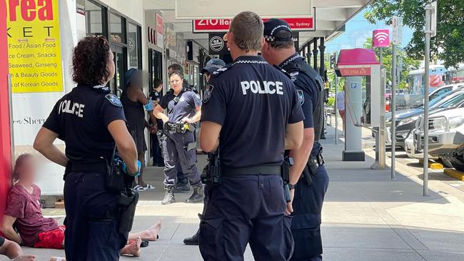 Nine police officers handcuffed four men on Lake Street in the Cairns CBD at around 12.30pm on Thursday.