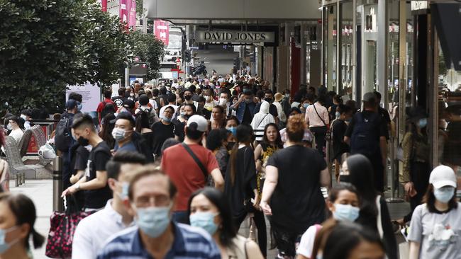 People walk along a busy Bourke Street Mall.