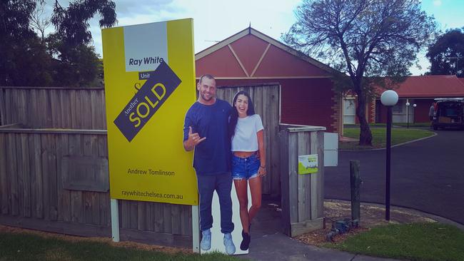 Josh Simons and partner Tatiana as a cardboard cut out, celebrating buying their first home while still in the United States.