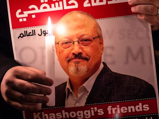 TOPSHOT - A demonstrator holds a poster picturing Saudi journalist Jamal Khashoggi and a lightened candle during a gathering outside the Saudi Arabia consulate in Istanbul, on October 25, 2018. - Jamal Khashoggi, a Washington Post contributor, was killed on October 2, 2018 after a visit to the Saudi consulate in Istanbul to obtain paperwork before marrying his Turkish fiancee. (Photo by Yasin AKGUL / AFP)