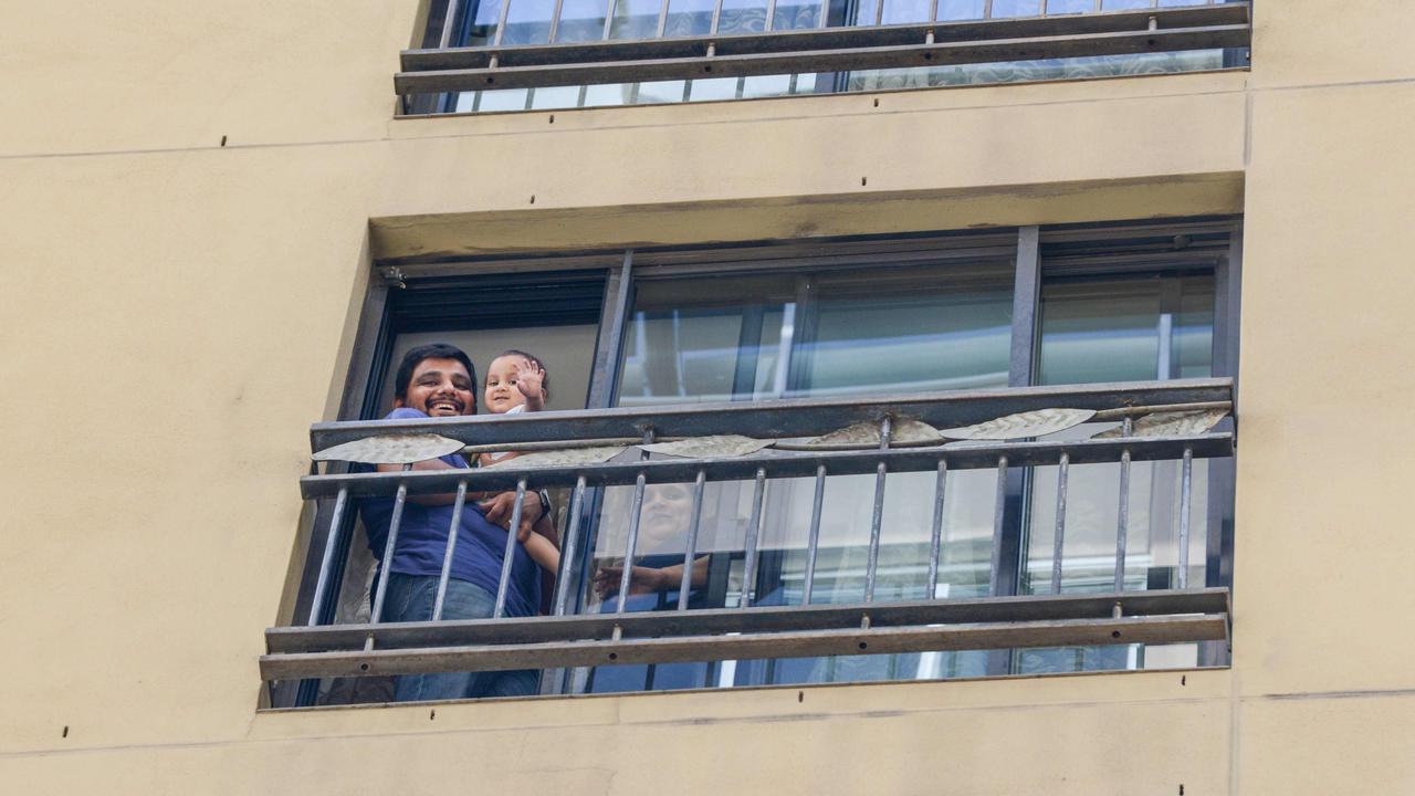 Australian residents wave from quarantine at a hotel in Adelaide. While these two appear to have a balcony, some have no access to fresh air. Picture: Brenton Edwards/AFP
