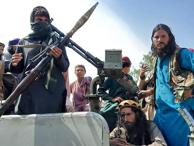 TOPSHOT - Taliban fighters sit over a vehicle on a street in Laghman province on August 15, 2021. (Photo by - / AFP)