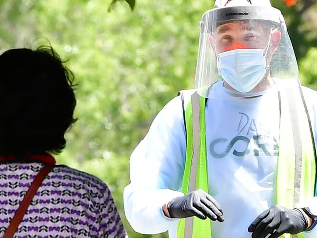 A volunteer dressed in full protective gear gives directions to a woman at a walk-in COVID-19 test site on June 30, 2020 in Los Angeles, California. - The US will start combining test samples to be tested in batches, instead of one by one, hoping to dramatically boost screening for the coronavirus, as California passes the threshold of 6,000 coronavirus-related deaths three months after statewide Stay-At-Home orders went into effect to try and stem the virus. (Photo by Frederic J. BROWN / AFP)