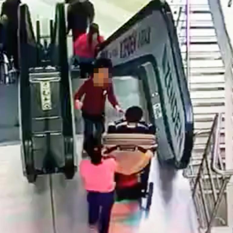 The children struggling to get the pram onto the escalator. Picture: Megapolis Moscow