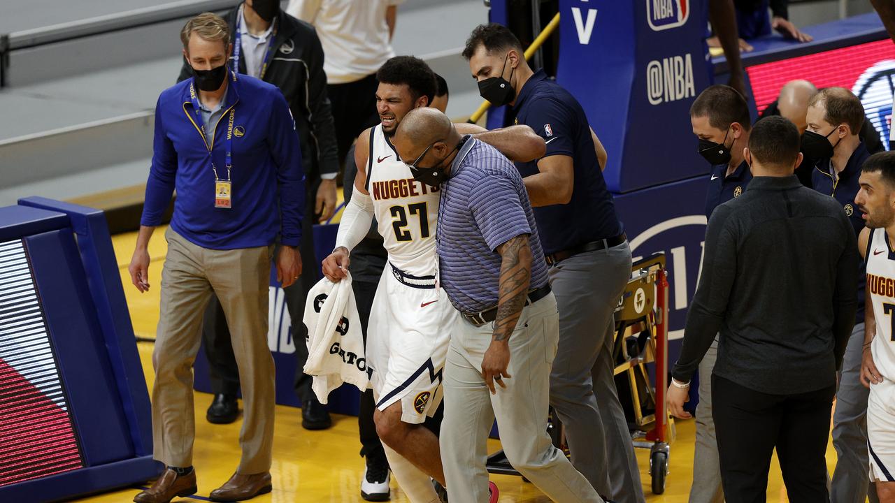Jamal Murray is helped off the court. (Photo by Ezra Shaw/Getty Images)