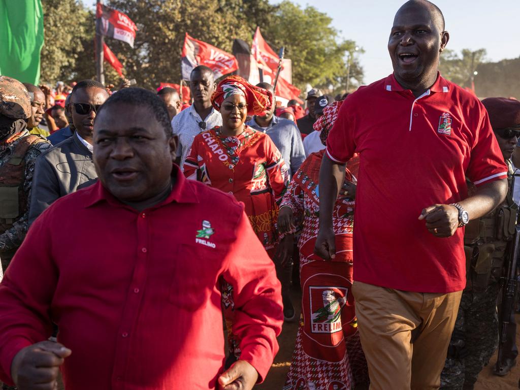 Presidential candidate for the ruling Mozambique Liberation Front (FRELIMO) Daniel Chapo (R) and incumbent President of Mozambique Filipe Nyusi (L) dance as they arrive to the closing rally on the final day of the electoral campaign.