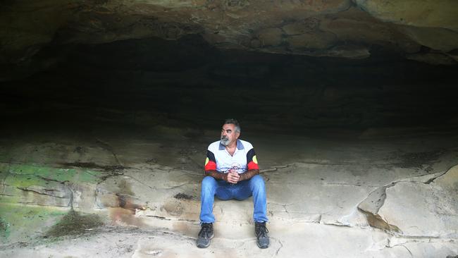 Wonnarua elder Uncle Warren Taggart at one of at least five Hunter Valley caves where thieves have chiselled out indigenous art dating back thousands of years. Picture by Peter Lorimer.