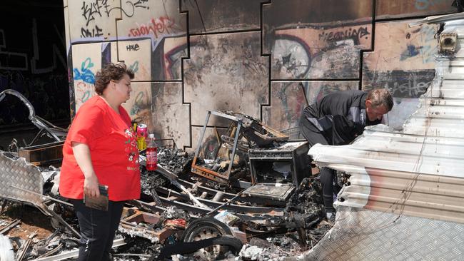 Rebecca Thomas going through burnt remains. Picture Dean Martin