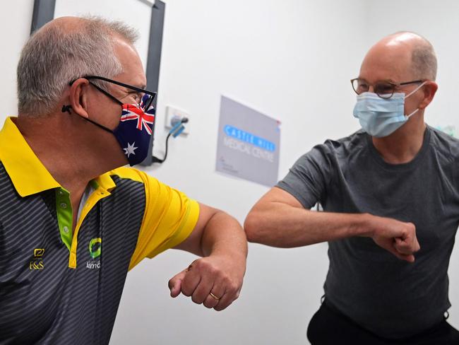 Australia's Prime Minister Scott Morrison (L) bumps elbows with Australian Government Chief Medical Officer Paul Kelly after they both received a dose of the Pfizer/BioNTech Covid-19 vaccine at the Castle Hill Medical Centre in Sydney on February 21, 2021. (Photo by Steven SAPHORE / AFP)