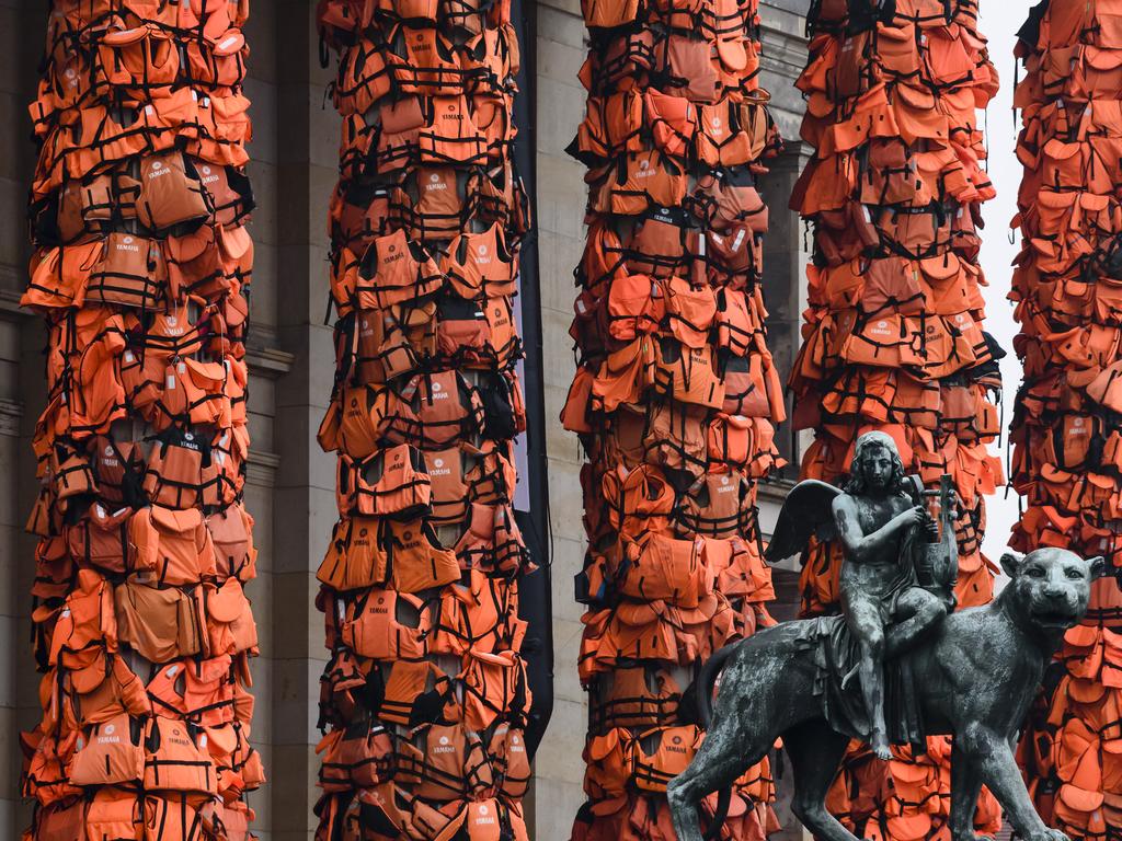 An art installation by Chinese artist Ai Weiwei that consists of life vests worn by refugees bound to the columns of the concert house next to a statue at Gendarmenmarkt on February 14, 2016 in Berlin, Germany. The life vests were among the thousands discarded by migrants and refugees after they crossed the sea from Turkey to Greece. Ai Weiwei lives in Berlin and is currently involved in several projects relating to refugees. Up to 80,000 refugees currently live in Berlin and the city is preparing for the likely arrival of 30,000 more in 2016. (Photo by Clemens Bilan/Getty Images)