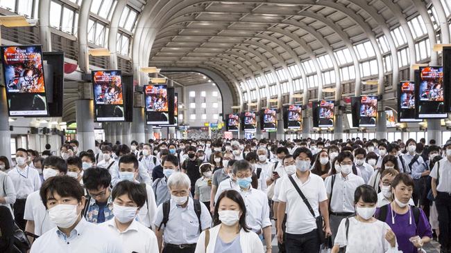 Commuters wearing face masks pass through Shinagawa train station in Tokyo, Japan. Picture: Getty Images