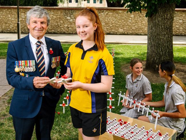 Veteran Don Corey, and St Aloysius College year 10 Emily Crocker, with year 9s Avalon Smeaton and Freja Milne planting the 2/43rd Batttalion Association memorial cross at the Field of Remembrance at the National War Memorial for Remembrance Day in Adelaide, Monday, November 9, 2020. (The Advertiser/ Morgan Sette)