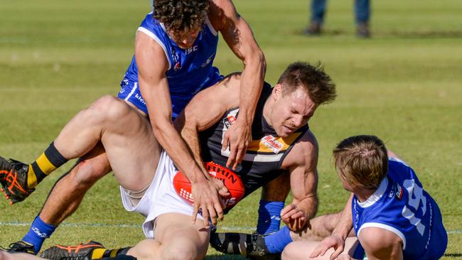 Brighton’s Nigel Osborn is tackled by St Peter’s Old Collegians opponents during a game last month. Picture: Brenton Edwards